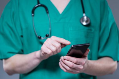 Doktorun telefonu kullanarak üniformalı yakın çekim