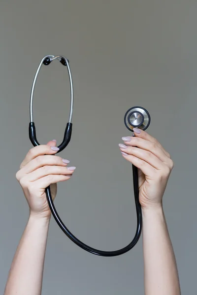 Female holding stethoscope in hands — Stock Photo, Image