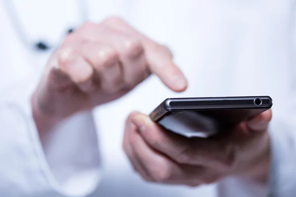 Close-up of hands of doctor using phone — Stock Photo, Image