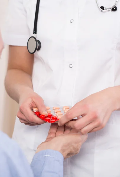 Les mains du médecin donnant des médicaments aux patients — Photo