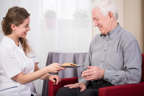 Zorg assistent en gepensioneerde man — Stockfoto