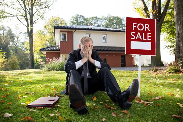 Tired estate agent is sitting on grass — Stock Photo, Image