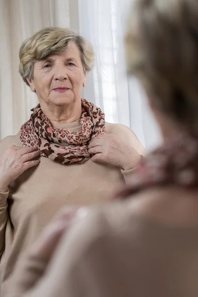 Frau blickt in den Spiegel — Stockfoto