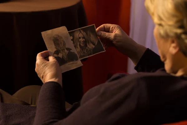 Бабушка смотрит на фотографии внуков — стоковое фото