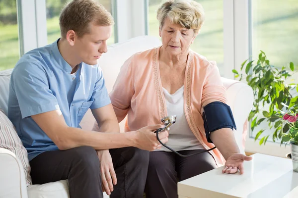 Verpleegkundige nemen bloeddruk — Stockfoto