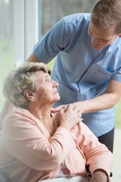 Медсестра-мужчина заботится о больной женщине — стоковое фото
