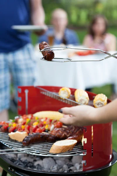 Frau nimmt Wurst — Stockfoto