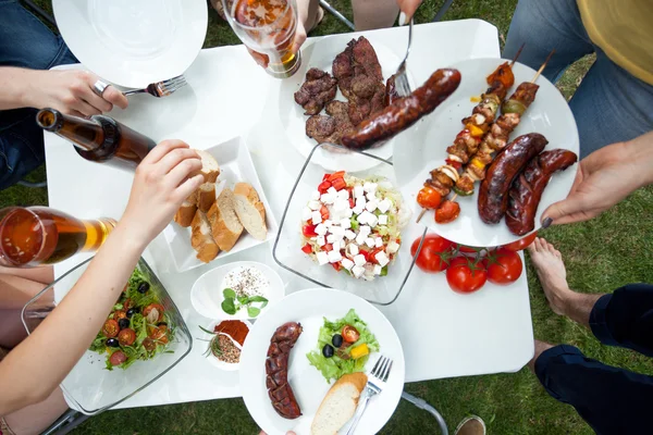 Pessoas comendo pratos grelhados — Fotografia de Stock