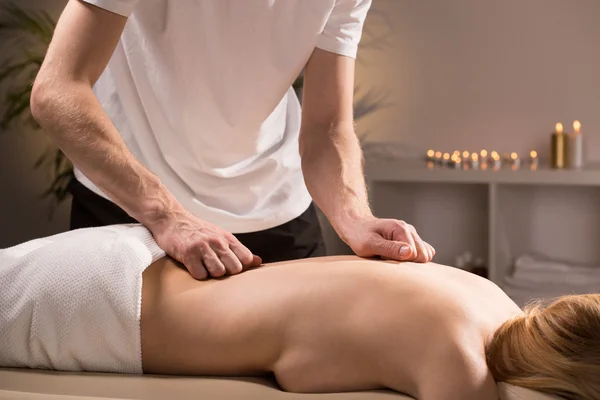Terapeuta massageando costas femininas — Fotografia de Stock