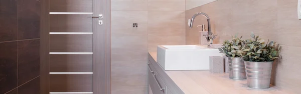 Металлический цветочный горшок в современной ванной — стоковое фото