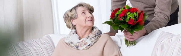 Seniorin bekommt Jubiläumsstrauß — Stockfoto