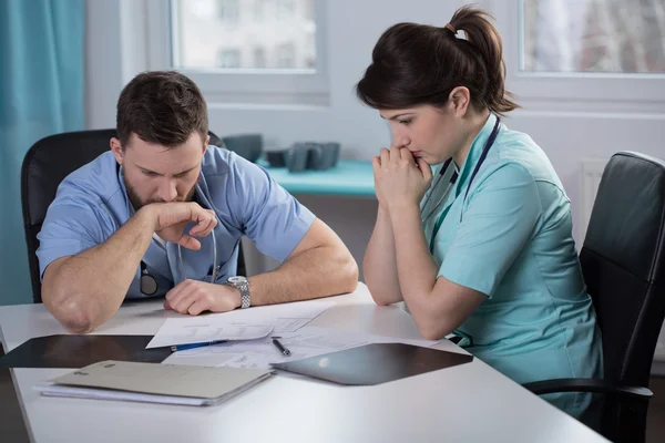 Besorgte Ärzte lesen Krankenakte — Stockfoto