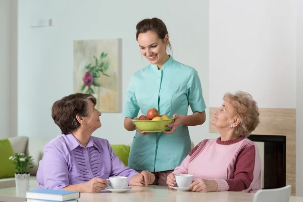 Verpleegkundige serveert thee en snacks — Stockfoto