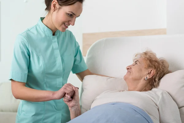 Ondersteunende verpleegster met oude dame — Stockfoto