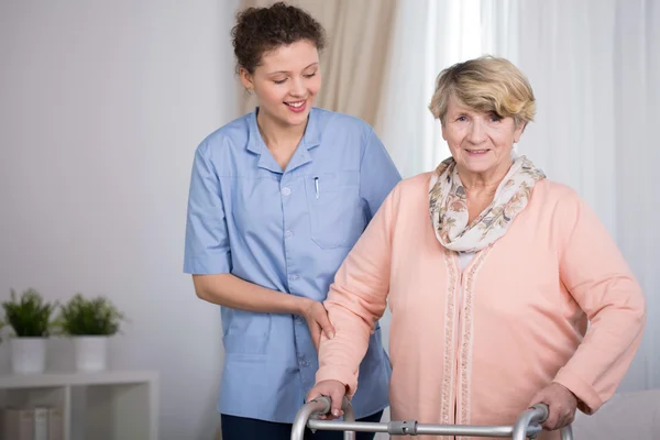 Senior vrouw en ondersteunende verpleegster — Stockfoto