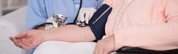 Médico que controla a pressão arterial do paciente — Fotografia de Stock