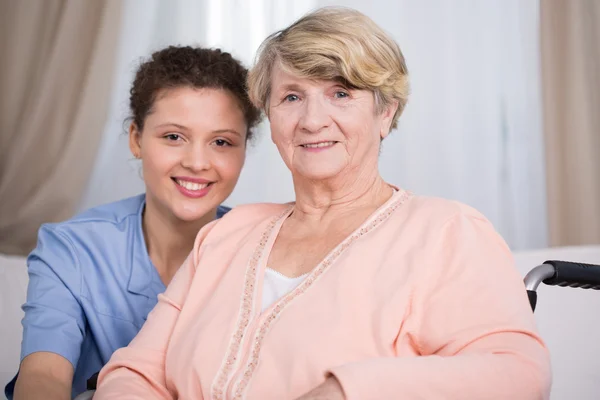 Senior vrouw en jonge verpleegster — Stockfoto