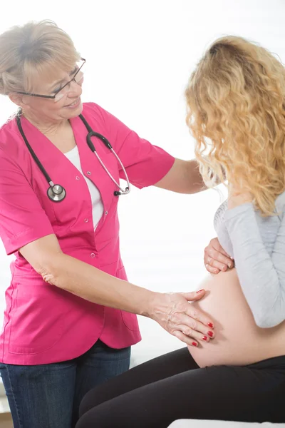 Gynecologist touching pregnant woman's belly — Stock Photo, Image