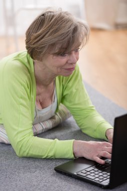 Bilgisayarı olan olgun bir kadın.