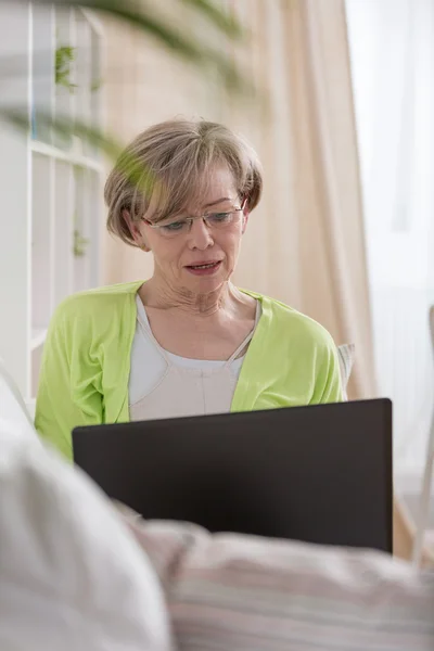 Oudere vrouw met laptop — Stockfoto