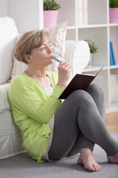 Volwassen vrouw zittend op de vloer — Stockfoto