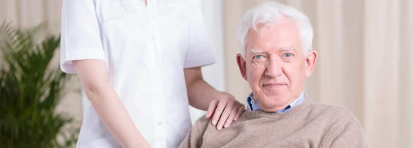 Lachende senior man en verpleegkundige — Stockfoto