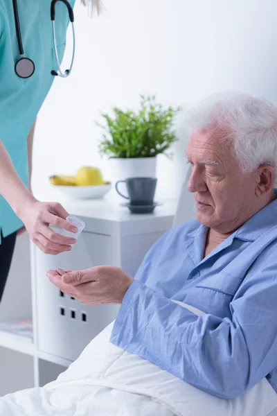 Pensioner lying in hospital bed — Stock Photo, Image