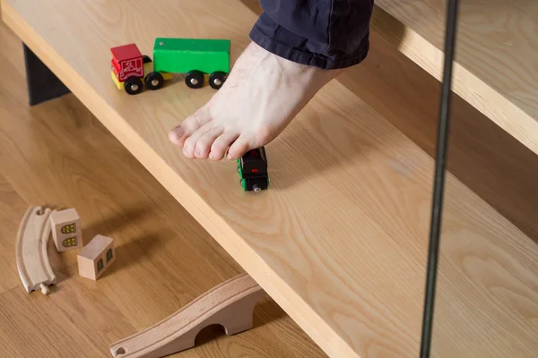 Man stepping on toys on stairs — Stock Photo, Image