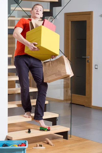 Man stepping on toys on stairs — Stock Photo, Image