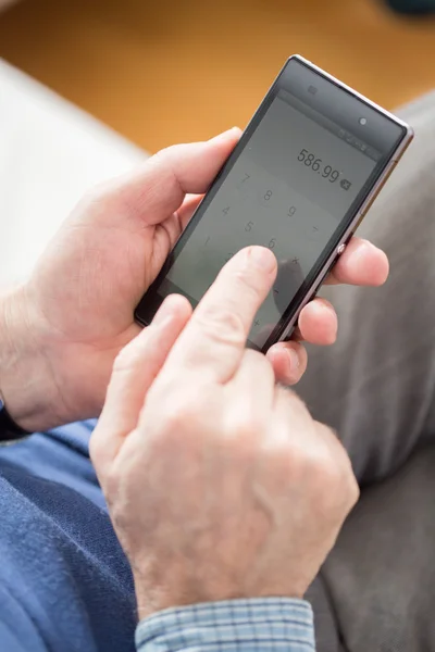 Mann benutzt Taschenrechner im Telefon — Stockfoto