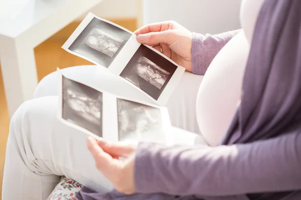 Budoucí matka sleduje ultrazvuk fotografie — Stock fotografie