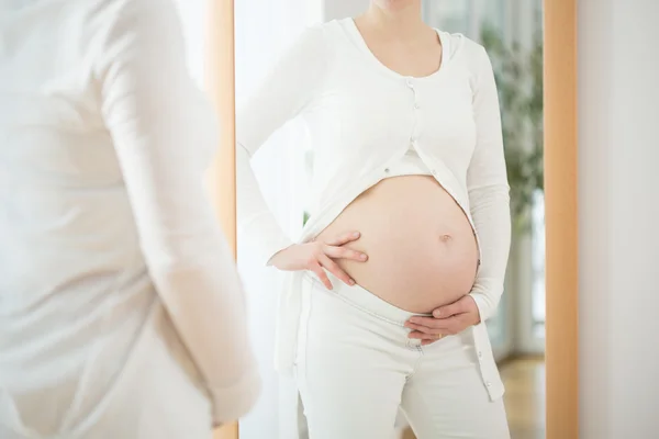 Zukünftige Mutter beobachtet ihren Bauch — Stockfoto