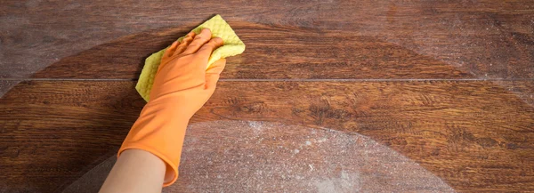 Schmutziges Parkett mit Handschuhen reinigen — Stockfoto