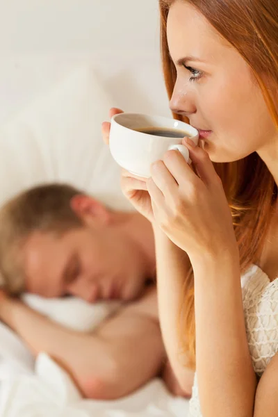 Woman drinking coffee in bed — Stock Photo, Image