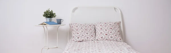 Weißes Bett mit Blumenbettwäsche — Stockfoto