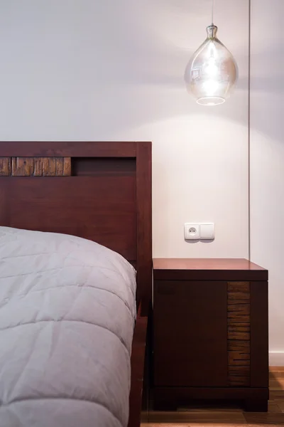 Drewniana Szafka nocna w przytulnej sypialni — Zdjęcie stockowe