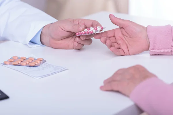 Les mains du médecin donnant des médicaments aux patients — Photo