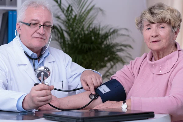Mujer mayor controlando la presión arterial — Foto de Stock