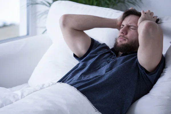 Сонный мужчина с головной болью — стоковое фото