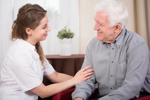 Smiling pensioner and caregiver — Stock Photo, Image