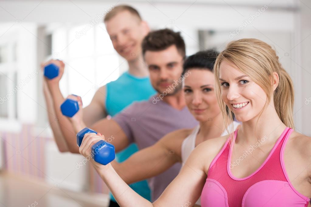 молодые инструкторы. человек стоит в зале. молодой тренер фото. тренер улыбается. боли клиентов в фитнесе.