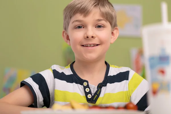 Boy eating breakfast in classroom — Stock Photo, Image