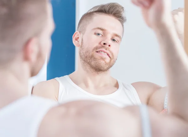 Hombre musculoso midiendo sus bíceps — Foto de Stock