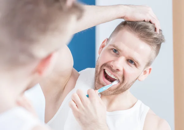 Handsome guy brushing his teeth — Stock Photo, Image