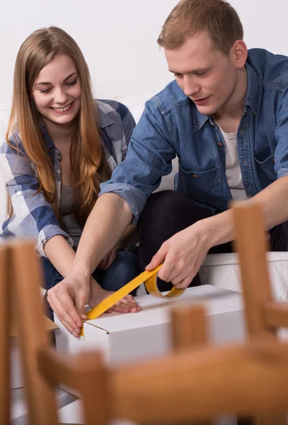 Couple sealing a moving box — Stock Photo, Image