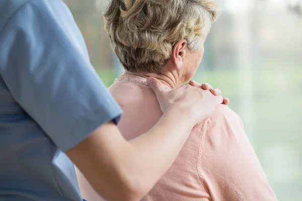 Hand on elderly woman's shoulder — Stock Photo, Image