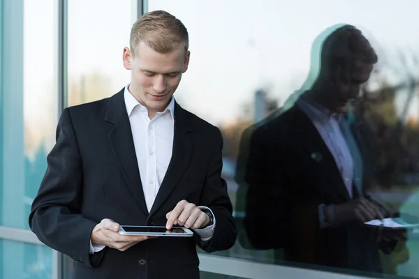 Bonito homem de negócios com um tablet — Fotografia de Stock