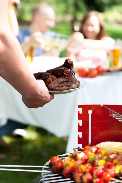 Man hand with plate of sausages — Stock Photo, Image