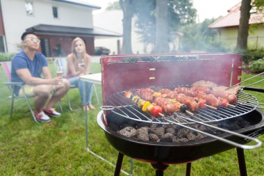 Bahçe Barbekü yanında oturan insanlar