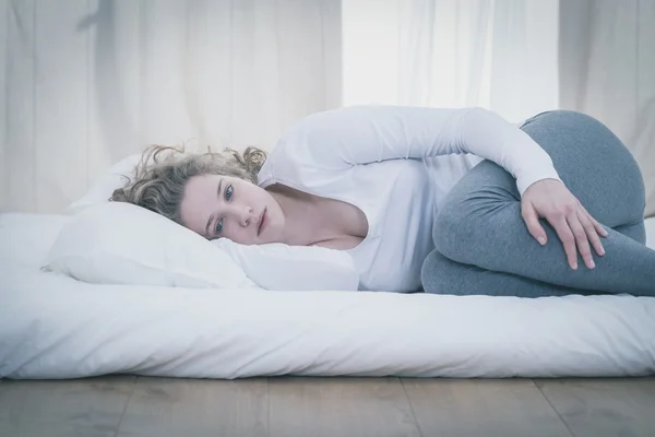 Vrouw liggen in gekruld positie — Stockfoto